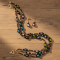 Beaded necklace and earrings set on a white background