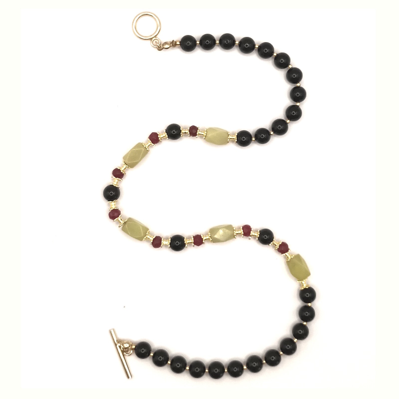 Beaded bracelet with black beads and gold accents on a white background