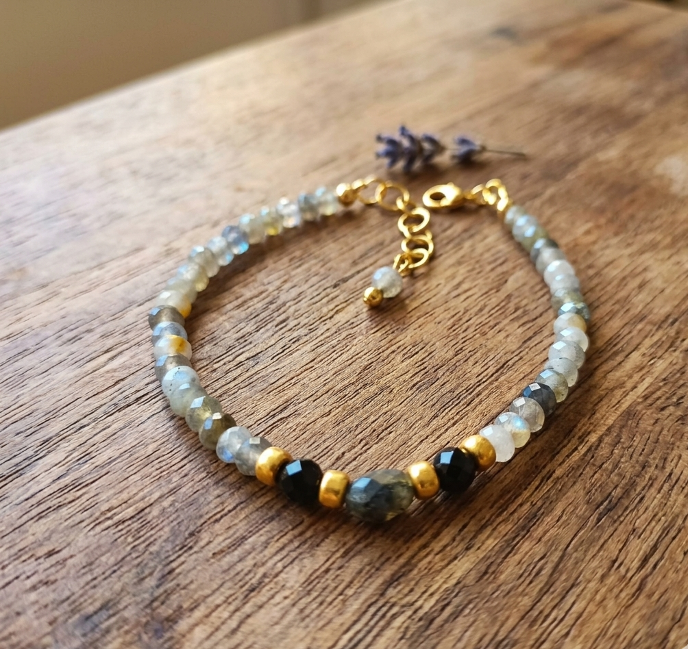 Beaded bracelet with gold accents on a wooden surface