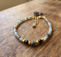 Beaded bracelet with gold accents on a wooden surface