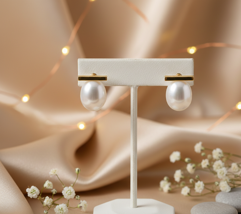 Pearl earrings on a white stand with a soft, blurred background