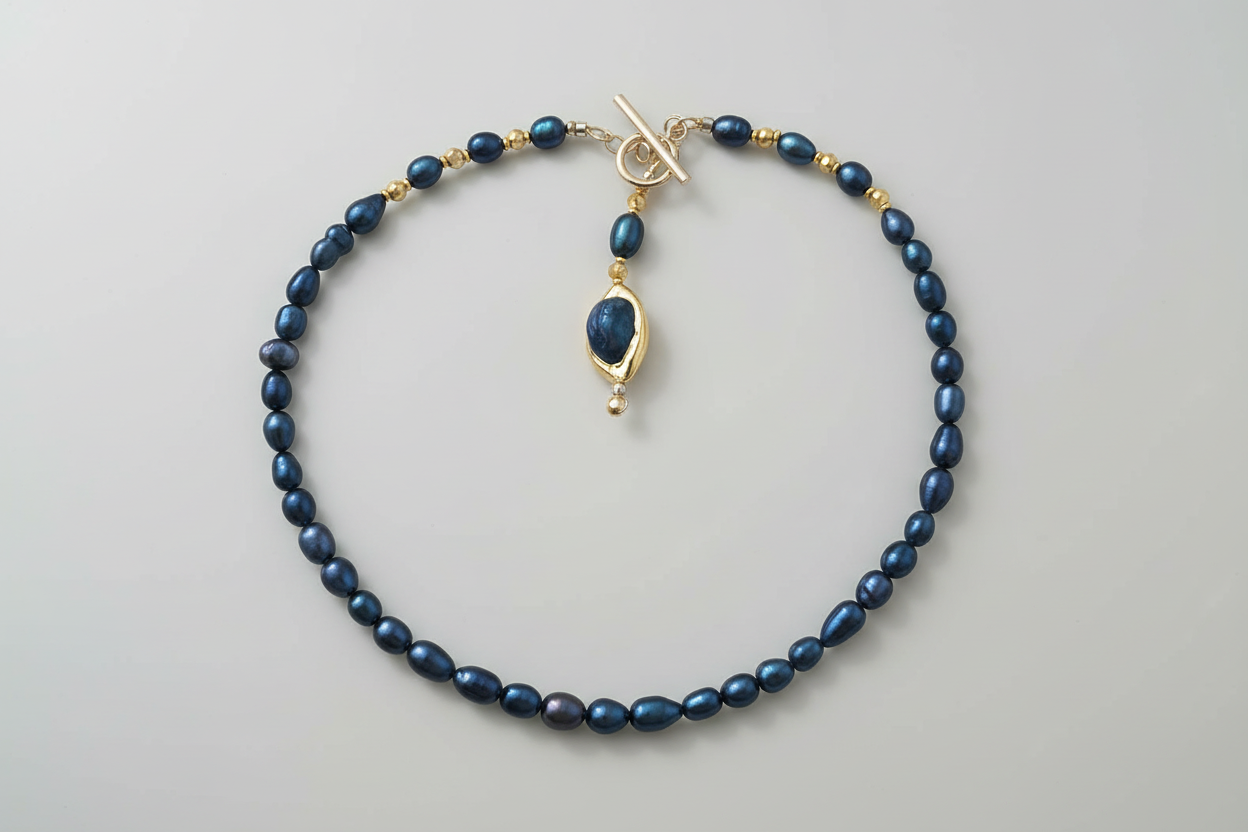 Blue beaded necklace with a gold clasp on a light gray background