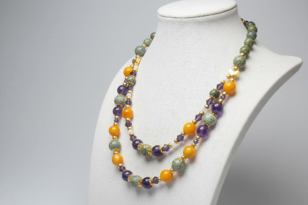 Multicolored beaded necklace on a mannequin bust against a gray background