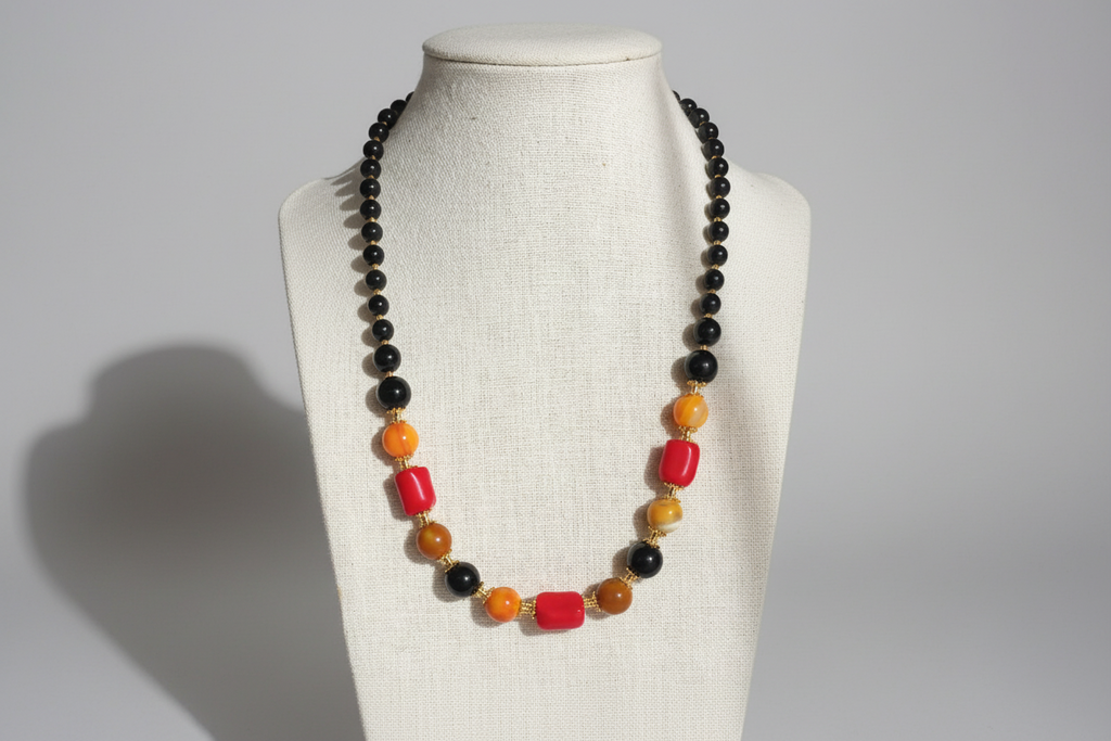 Necklace with multicolored beads on a mannequin bust against a plain background