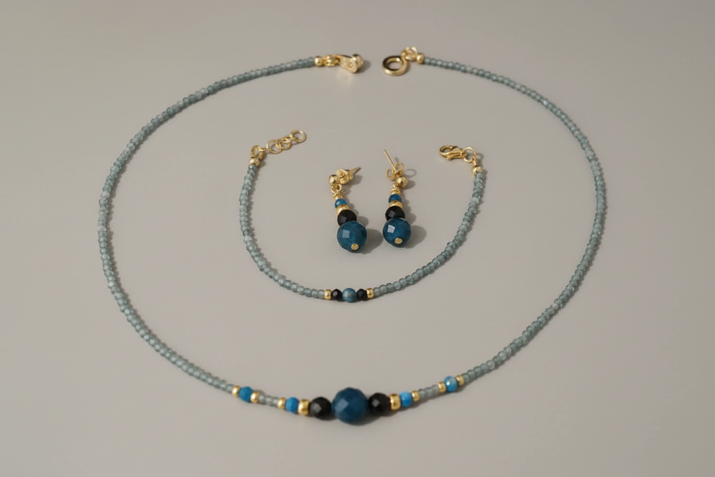 Jewelry set with necklace, bracelet, and earrings on a gray background