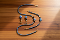 Blue beaded necklace and earrings on a wooden surface